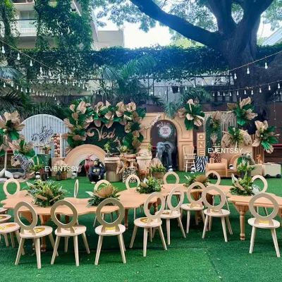 A full view of the 'Wild One' jungle party, complete with themed kid-sized tables and chairs set up on artificial turf for an immersive experience.