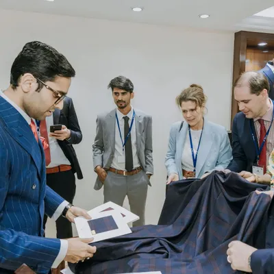 The journey to a bespoke suit begins with the fabric. Here, we are presenting a client with a selection of premium Scabal fabrics, discussing the unique properties of a fine wool plaid for their custom garment.