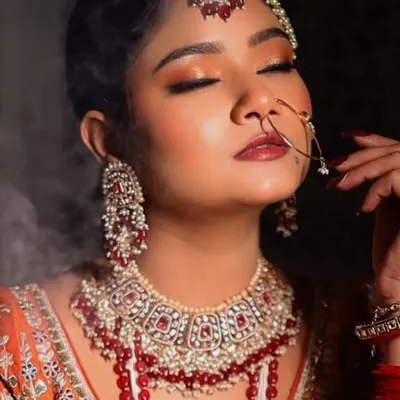 A close-up of a full glam Nikkah look, with eyes closed to showcase the soft, peachy-golden glittery eyeshadow. The look is dramatic yet elegant, perfect for a bride.