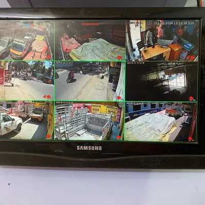 A live view from a nine-camera system on a Samsung monitor. I ensure your system is set up to easily view all your cameras at once, covering different areas like a storefront, warehouse, and parking lot.