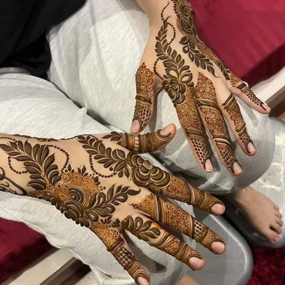 A beautiful example of a modern Arabic fusion design, featuring bold leafy vines and delicate filler patterns that flow elegantly across the hands.