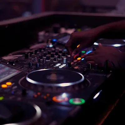 A close-up of my hands adjusting the levels on the mixer. This is where I fine-tune the sound, ensuring every element of the track is perfectly balanced.
