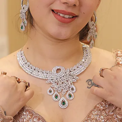 A stunning diamond-look necklace with emerald and ruby drops, paired with a sequin blouse. This shows how our jewelry can elevate any modern or cocktail outfit.