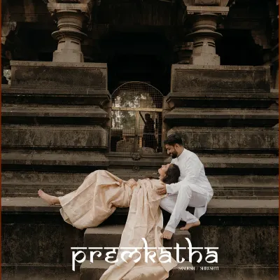A 'premkatha' captured in stone and emotion. The couple shares a quiet moment on the steps of a historic temple, their traditional attire blending perfectly with the timeless surroundings.