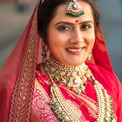 A close-up of this royal and elegant bride. Her makeup features soft, defined eyes and a natural lip color, allowing her stunning traditional jewelry to shine. This look is all about creating a regal yet authentic bridal appearance.