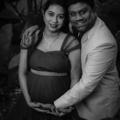 A classic black-and-white couple's portrait. This timeless style emphasizes their expressions and the protective way they hold the baby bump, creating a powerful, emotional photo.