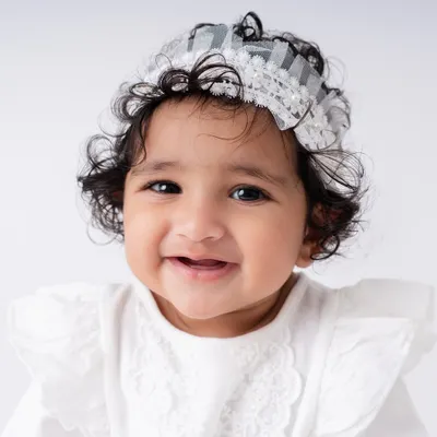 A close up of a happy sitter. At this age, their expressions are priceless. This little girl's smile and bright eyes show the pure joy of a 7 month old baby, which I love to capture.