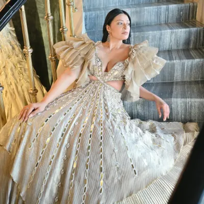 A full view of this magnificent couture gown, showcasing its tiered structure and intricate metallic detailing. When styling for a major event, the goal is to choose a piece that not only looks stunning but also photographs beautifully from every angle.