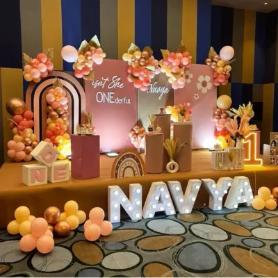 A trendy "Isn't She ONEderful" themed first birthday with a warm, earthy color palette. This boho-chic setup features marquee letters, modern arched backdrops, and balloon clusters in shades of terracotta and rose gold.