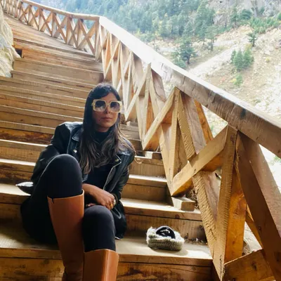 Hello winters. A classic winter travel look with a black leather jacket, black leggings, and tall brown boots. This outfit is perfect for exploring a chilly mountain destination in style.