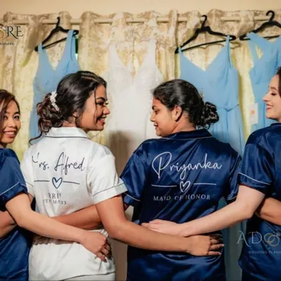 The bride and her maid of honor sharing a happy moment before the ceremony. We help coordinate these pre-wedding photoshoots, complete with custom satin robes for the entire bridal party.