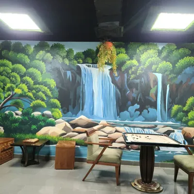 A serene waterfall mural painted in a recreational area at the Leela Ambience Hotel in Gurugram. This artwork transforms the room into a peaceful natural escape, perfect for relaxation.