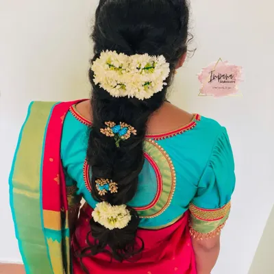 A beautiful messy braid for a housewarming ceremony. This hairstyle combines traditional elements with a modern twist, using fresh flowers and decorative pins for an elegant finish.