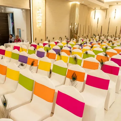 For a Radha Krishna themed Garba night, I used peacock feathers and vibrant, colorful sashes on the chairs to bring the theme to life throughout the venue.