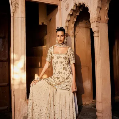 A sharara set that feels like a dream. The intricate sequin work on this beige ensemble creates a look of pure, understated glamour, perfect for a festive evening.