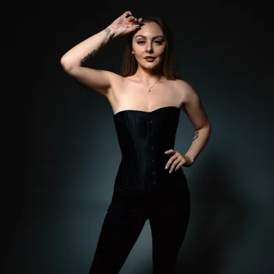 A studio portrait session playing with light and shadow. The black corset and dark background reflect the deep, atmospheric side of my melodic techno productions.