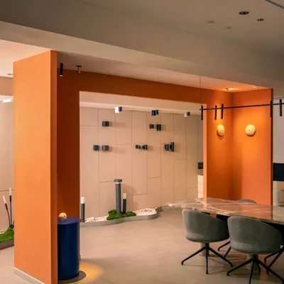 A wide view of the showroom, where a bold orange archway frames the main display area. This architectural feature adds a vibrant pop of color and helps to zone the space without using walls.
