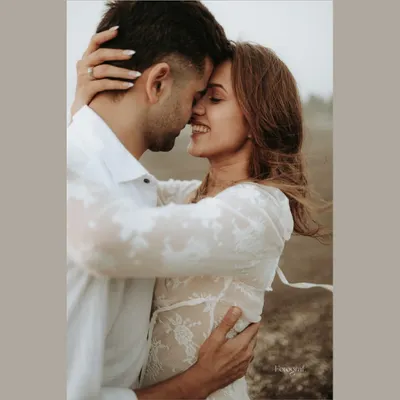 Literally bathing in sunshine. A close-up, intimate pre-wedding shot of a couple embracing, full of warmth and genuine smiles.