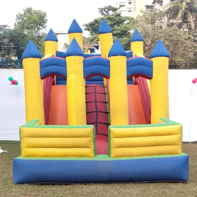 A large castle-style bouncer with yellow turrets and blue walls. This inflatable includes a climbing section and a small slide inside for extra fun.