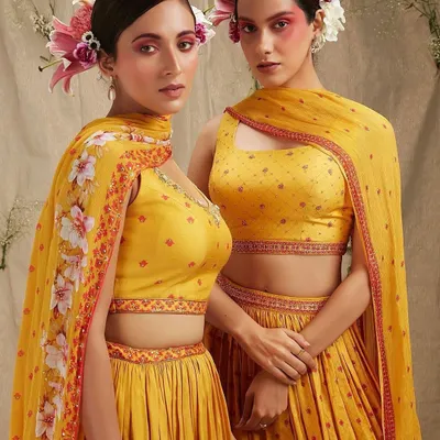 A high-fashion, artistic look perfect for a themed sangeet or a creative pre-wedding shoot. The bold, colorful blush and fresh flowers in the hair create a memorable and unique bridal statement.