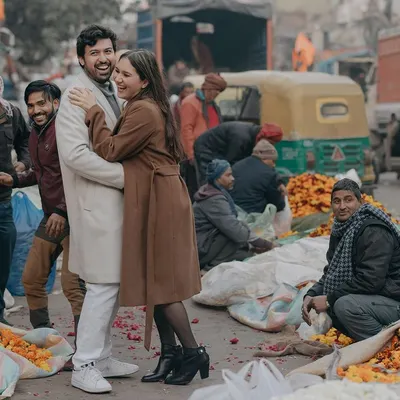 A spontaneous, joyful hug amidst the bustling flower markets of Old Delhi. We thrive on capturing authentic moments of love in real, vibrant environments.