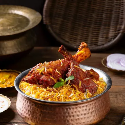 A Hyderabadi chicken biryani, styled with traditional copper and brass serveware for The Nawaab’s. The lighting is crafted to highlight the texture of the rice and the rich color of the chicken.
