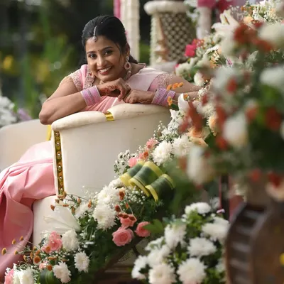 Dr. Namratha looking absolutely lovely during her ring ceremony. Seated amidst beautiful floral decor, her soft pink saree and fresh makeup look perfect for this happy, daytime occasion.
