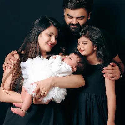 A beautiful family portrait with a mother, father, and two children. I love capturing the connection between everyone, especially the older sister looking lovingly at her new baby sibling.