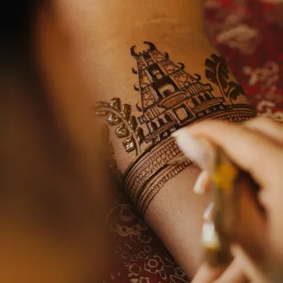 A close-up shot of me creating a detailed temple motif on a bride's arm. Every line is carefully drawn to ensure the final design is perfect.