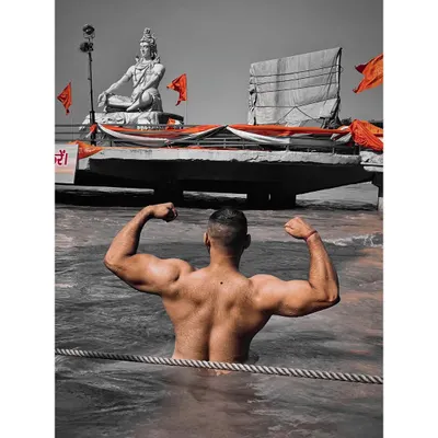 Strength and devotion in one frame. Flexing my back in the holy Ganga river with the iconic Shiva statue of Rishikesh in the background.