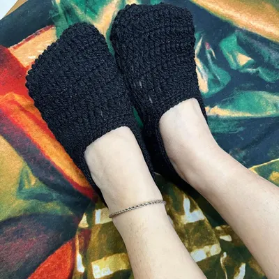 Keep your feet warm with our handmade crochet socks. This is a pair of simple black ankle socks, perfect for wearing around the house.