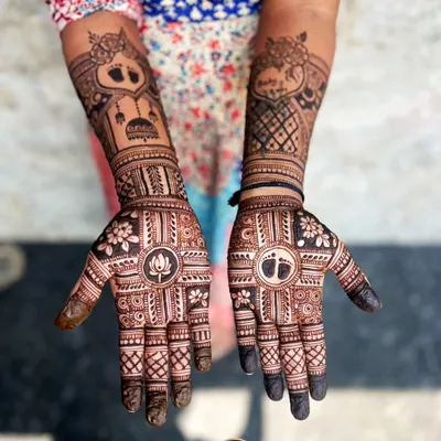 A beautiful and intricate baby shower henna design. We included a lotus on one palm and baby feet on the other, along with personalized elements on the arms to celebrate the occasion.