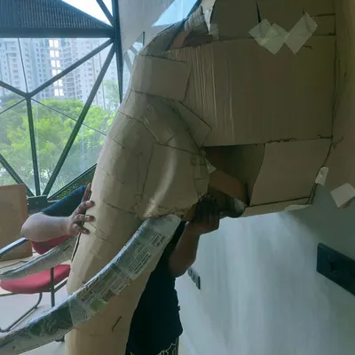 This is how the giant cardboard elephant head began. Our team is seen here shaping and taping individual pieces of cardboard to build the complex structure before the final details were added.