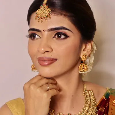 A close-up of a classic South Indian bridal look created by our students, focusing on achieving a radiant base, sharp winged eyeliner, and perfectly defined brows to complement traditional gold jewelry.