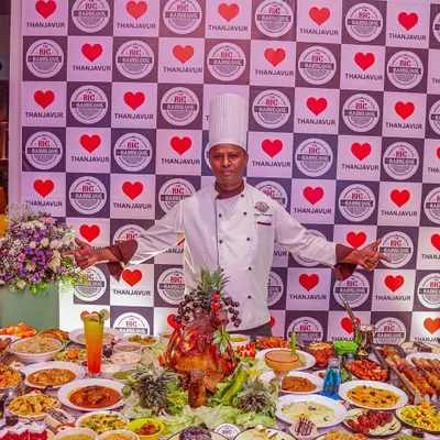 Our chef stands proudly behind a table overflowing with our signature dishes. This image captures the scale of our grand buffet, perfect for weddings, corporate events, and large family celebrations.