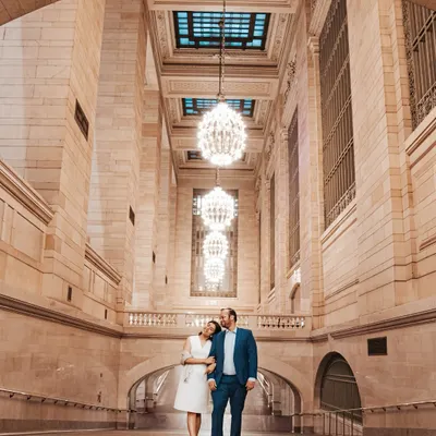 A stunning portrait of a couple standing in New York's Grand Central Station. The grand architecture and beautiful chandeliers create a timeless and sophisticated backdrop for their urban love story.