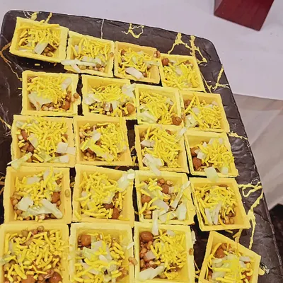 Bite-sized chaat served in edible square canapés. These single-serving appetizers are easy for guests to eat while networking and are a modern twist on a classic snack.
