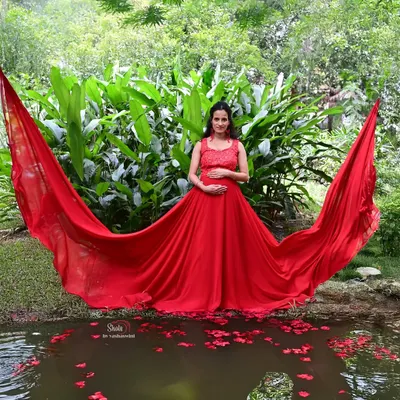 Our red flying gown looks incredible for waterside maternity shoots. The long fabric trail floating on the water creates a stunning and artistic photograph.