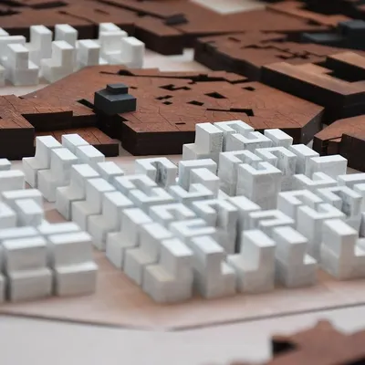 This urban massing model, crafted from wood, helps us understand the relationship between existing structures and new interventions. It is a tool for studying density, scale, and the creation of public space at a city level.