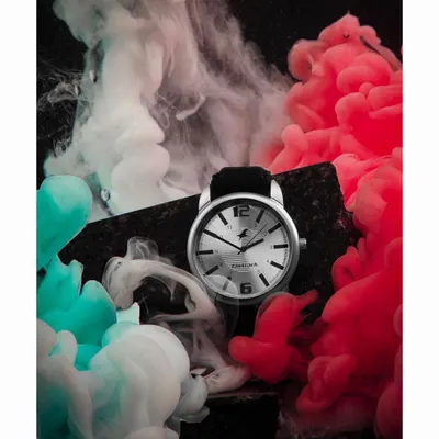 A highly creative advertising shot for a Fastrack watch, using red and white smoke to create a dynamic and energetic mood. This kind of conceptual photography is designed to capture attention and build brand hype.