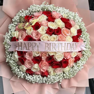 Our signature grand bouquet, featuring a dense circle of red, pink, and white roses surrounded by a halo of baby's breath. Wrapped in soft pink paper with a "Happy Birthday" ribbon, it is the epitome of celebratory floral design.