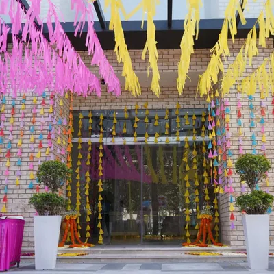 First impressions matter. I created this joyful and colorful entrance using bright paper streamers and hanging tassels to set a festive tone for a corporate Holi party right from the moment guests arrived.