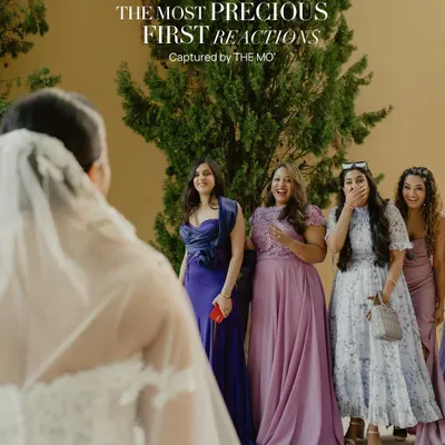 The most precious first reactions. This shot captures the pure, unscripted joy and surprise on the faces of bridesmaids as they see the bride for the first time, a moment of genuine emotion and friendship.