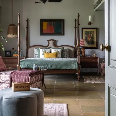This bedroom in a Dhaka residence is a perfect example of a cultured, cozy retreat. A classic four-poster bed is the centerpiece, complemented by custom furniture and art sourced from around the world. The stone flooring and soft lighting create a humble yet elegant vibe.