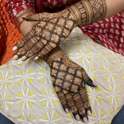 This design is a masterpiece of traditional patterns. The hands are covered in a dense lotus jaal (net), which requires a very steady hand and creates a stunning, textured look once the stain develops.