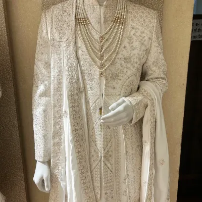 The essence of class is in simplicity and detail. This all-ivory sherwani features tone-on-tone embroidery, paired with a matching stole and a multi-strand pearl necklace for a look of pure elegance.