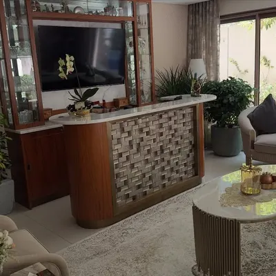 Plants can soften and elevate modern interiors. In this living room, I placed several large potted plants to complement the furniture and add life to the space, including one by the large window to connect with the outside.