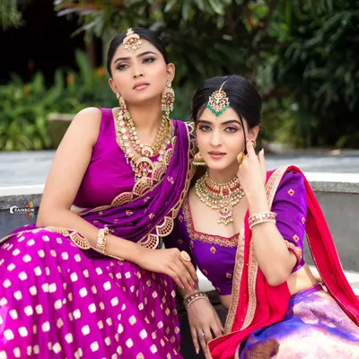 We love creating coordinated looks for bridesmaids or friends. Here, we styled two complementary half-sarees in shades of purple and pink, showcasing our custom design and group styling services.