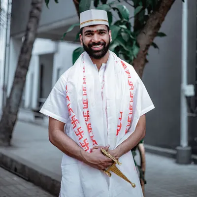 A smiling portrait of the groom during his Haldi ceremony, dressed in traditional white attire.