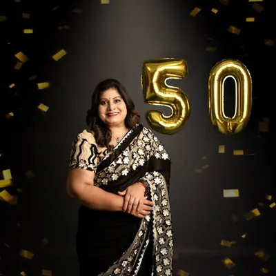 Celebrating 50 years with style and joy. This portrait captures a moment of celebration with golden confetti, marking a golden milestone in a fun and elegant way.
